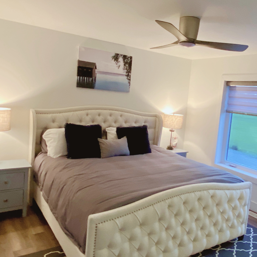 Cozy modern bedroom with a tufted cream-colored bed frame and a mauve comforter.